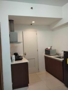 a small kitchen with a sink and a microwave at Roxas Blvd Stunning Studio Condo Near US Embassy in Manila