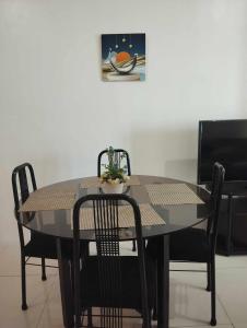 une table noire avec des chaises et une photo sur le mur dans l'établissement Roxas Blvd Stunning Studio Condo Near US Embassy, à Manille