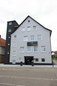 a large white building with a sign on it at V Business Appartments Stuttgart Magstadt in Magstadt