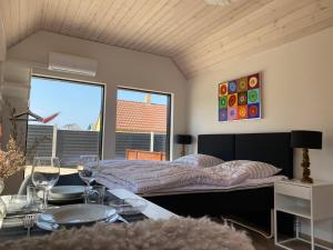 1 dormitorio con 1 cama y 1 mesa con copas de vino en Esehytter Luxury Holiday Home near Beach, en Nørre Nebel