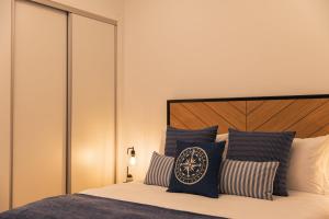 a bedroom with a bed with blue and white pillows at Varanda Azul - First Mate Loft (City Centre) in Ponta Delgada