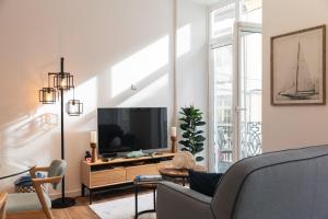 a living room with a tv and a couch at Varanda Azul - First Mate Loft (City Centre) in Ponta Delgada