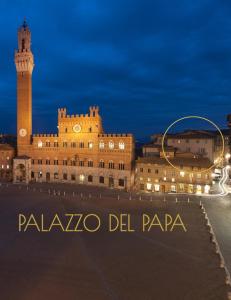 vistas a un edificio con una torre de reloj por la noche en Palazzo del Papa, en Siena