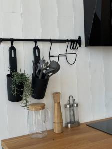 encimera de cocina con ollas y utensilios en la pared en Modernūs apartamentai Svencelėje, en Svencelė