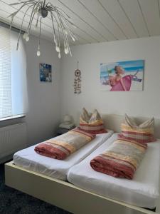 two beds with pillows on them in a room at Nordwind Sjut in Warnow