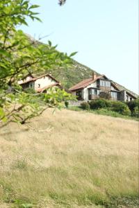 zwei Häuser auf einem Grashügel in der Unterkunft La Montaña Mágica Hotel Rural in Vibaño