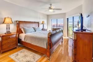 a bedroom with a bed and a dresser with a television at Land's End 3-404 Bay Front in St Pete Beach