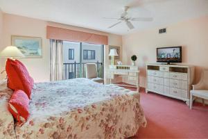 a bedroom with a bed and a television in it at Land's End 8-401 Beach Front in St. Pete Beach