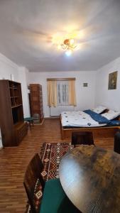 Sala de estar con cama y mesa en Casa Viorica, en Câmpulung Moldovenesc
