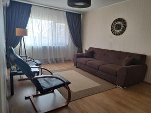 a living room with a couch and a chair at Relax Apartament in Constanţa