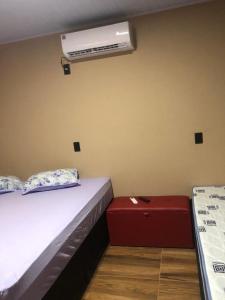 1 dormitorio con 1 cama y aire acondicionado en la pared en Chalé sossego en Pirenópolis