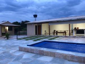 un patio trasero con piscina y una casa en Chalé sossego en Pirenópolis