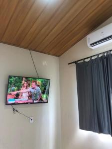 TV colgada en la pared de una habitación en Chalé sossego en Pirenópolis