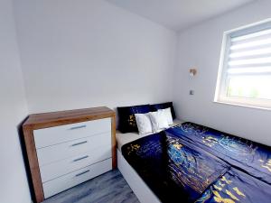 a bedroom with a bed with a dresser and a window at Spokojny zakątek in Ustroń