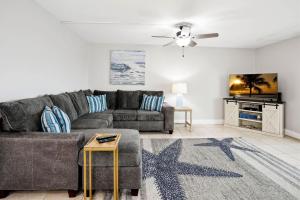 sala de estar con sofá gris y ventilador de techo en Holiday Villas II 407 Premier, en Clearwater Beach