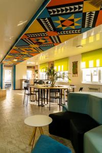 a restaurant with tables and chairs and a colorful ceiling at People Hostel & Coworking in Bishkek
