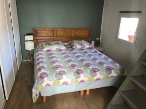 una camera da letto con un letto con un piumone colorato e una finestra di Longo Mai ad Apt
