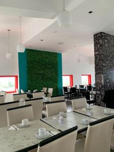 jadalnia ze stołami i krzesłami oraz zieloną ścianą w obiekcie Hotel internacional w mieście Termas de Río Hondo