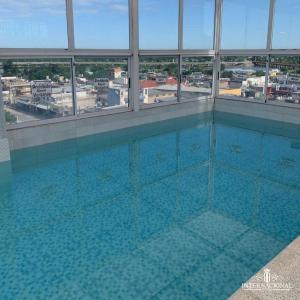uma grande piscina num edifício com janelas em Hotel internacional em Termas de Río Hondo