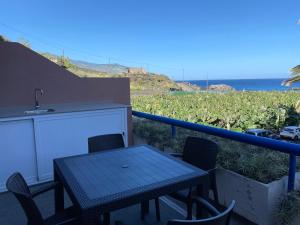 un tavolo e sedie su un balcone con vista sull'oceano di Vivienda vacacional “Punta de la arena” a Breña Baja
