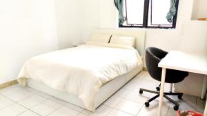 um quarto com uma cama, uma secretária e uma cadeira em Ms. Zhang Apartment em Abu Dhabi