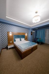 a bedroom with a large bed and a blue wall at Royal Boutique Baku in Baku