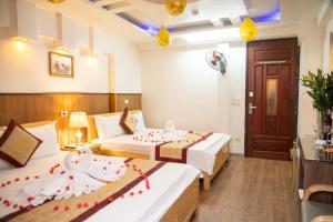 ein Hotelzimmer mit 2 Betten mit Dekorationen darauf in der Unterkunft Hà Thành Hotel - Ngõ 63 Lê Đức Thọ, Mỹ Đình - by Bay Luxury in Hanoi