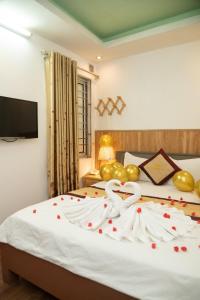 ein Schlafzimmer mit einem Bett mit Herz und Rosen darauf in der Unterkunft Hà Thành Hotel - Ngõ 63 Lê Đức Thọ, Mỹ Đình - by Bay Luxury in Hanoi