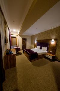 um quarto de hotel com uma cama grande e uma mesa em Royal Boutique Baku em Baku