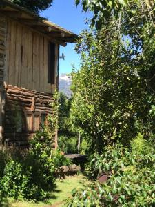 an old cabin in the woods next to a garden at Costa del azul in Los Repollos