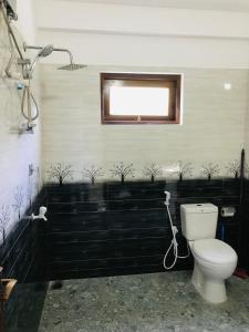 a bathroom with a white toilet and a window at Star Beach Villa in Tangalle