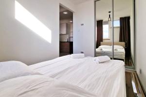 una camera da letto con un grande letto bianco e uno specchio di Remote Work GEM - FREE parking - top location a Varsavia