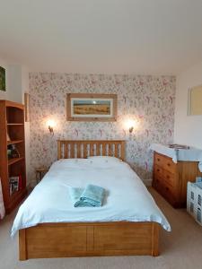 a bedroom with a large bed with flowers on the wall at Mapperton Barn House B&B Nr Stourhead & Longleat in Mere