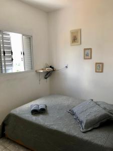 ein Schlafzimmer mit einem Bett mit einem Paar Schuhe darauf in der Unterkunft Serra da Canastra - Casa em Vargem Bonita/MG in Vargem Bonita