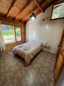 a bedroom with a bed in a wooden room at Cabaña La Elisa in Villa La Angostura