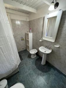 a bathroom with a sink and a toilet and a mirror at Cabaña La Elisa in Villa La Angostura +14 photos