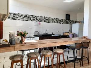 uma cozinha com um balcão com bancos de bar em Serra da Canastra - Casa em Vargem Bonita/MG em Vargem Bonita