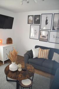 a living room with a blue couch and a table at TKS HOME Zur Tenne in Norken