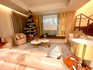 a living room with a white couch and a christmas tree at Shine HolliDay Villa HaNoi in Hanoi