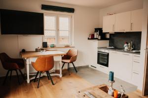 a kitchen with a table and chairs in a room at Wohnung Schrödelstein neues Highlight Fliegenfischen auf der Isar in Lenggries