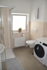 a bathroom with a toilet and a washing machine at TKS HOME Zur Tenne 
