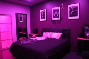- une chambre violette avec un lit à éclairage rose dans l'établissement SECRET33, à Floirac