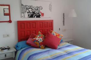 a bedroom with a red headboard and a bed with pillows at Apartamento Primera Linea de Playa. DENIA in Denia +46 photos