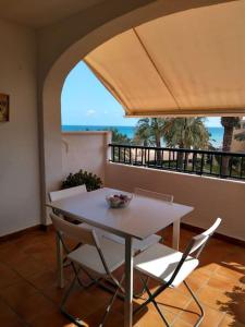 a table and chairs in a room with a balcony at Apartamento Primera Linea de Playa. DENIA in Denia
