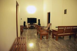 d'un salon avec des chaises et une télévision à écran plat. dans l'établissement Preethi Village, à Negombo