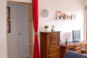 a door with a red curtain next to a desk with a television at Apartamento Primera Linea de Playa. DENIA in Denia