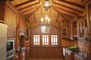 a kitchen with a large window and wooden ceilings at Preethi Village in Negombo