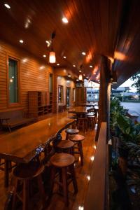 un bar con mesas de madera y sillas en un restaurante en HUAN CHOM JAN Hometel at Lampang, 