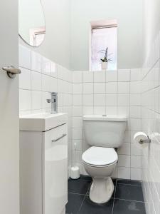 a white bathroom with a toilet and a sink at Boutique Heaven in South Yarra in Melbourne