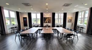 uma grande sala com mesas e cadeiras em Privat & Boutique Hotel Plauer See em Funfseen